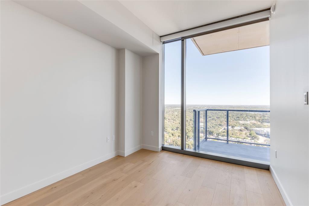44 East Avenue, Unit 3109 Austin, TX 78701 - Photo 7 of 37 Empty room with light wood-style flooring, baseboards, and expansive windows