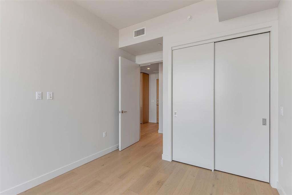 44 East Avenue, Unit 3109 Austin, TX 78701 - Photo 9 of 37 Unfurnished bedroom featuring a closet, visible vents, baseboards, and light wood-style floors