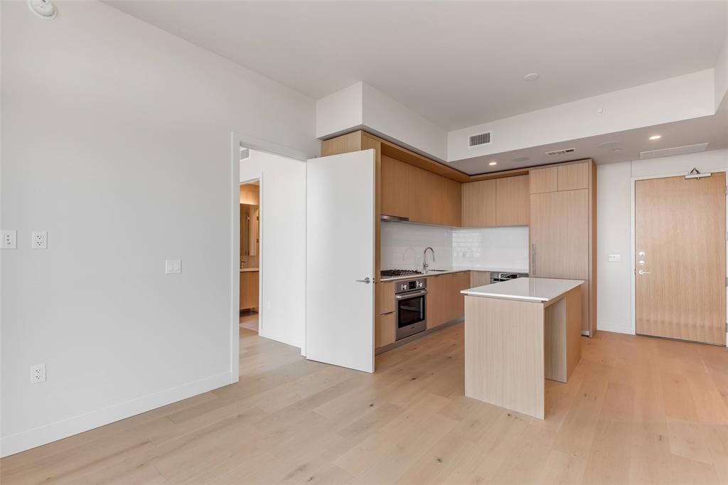 44 East Avenue, Unit 3109 Austin, TX 78701 - Photo 10 of 37 Kitchen with light wood-style flooring, a sink, light countertops, stainless steel oven, and modern cabinets