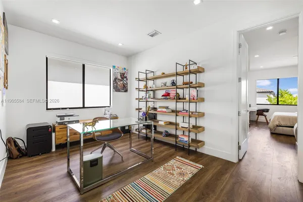 a bedroom with a bed and wooden floor