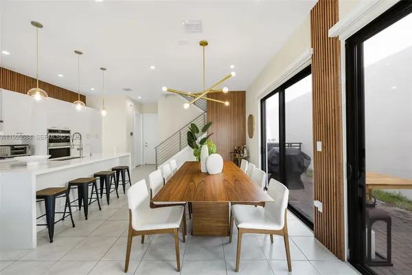 a dining room with furniture and a floor to ceiling window