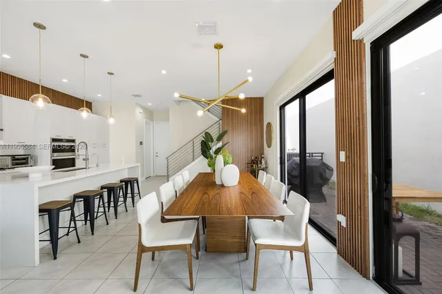 a dining room with furniture and a floor to ceiling window