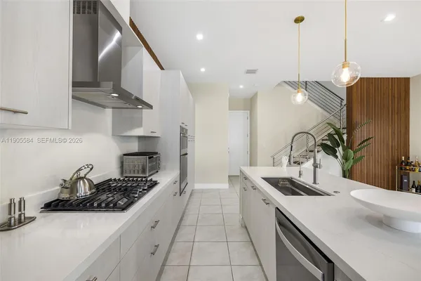 a kitchen with stainless steel appliances a sink a stove and a wooden floor