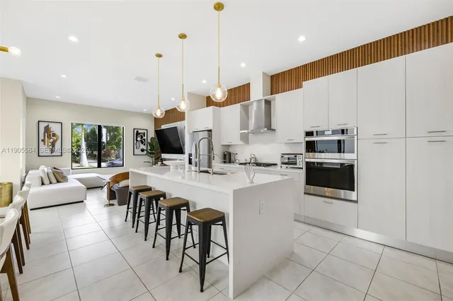 a kitchen with stainless steel appliances kitchen island granite countertop a table and chairs in it