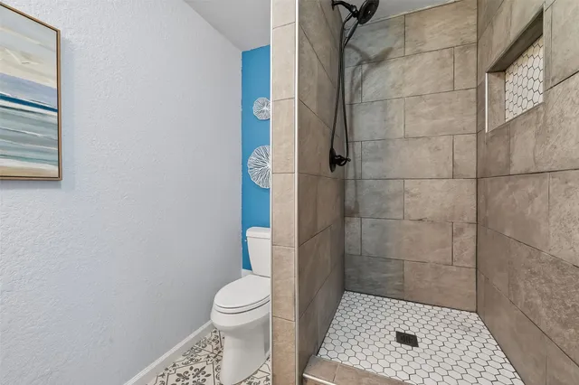 a bathroom with a toilet and a shower