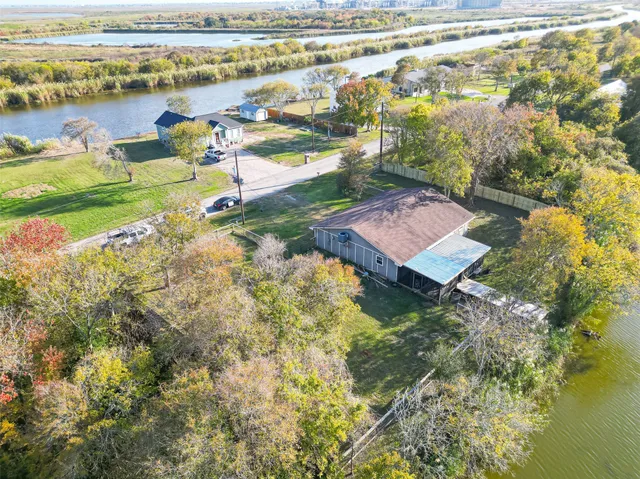 a aerial view of a house with a yard and large trees