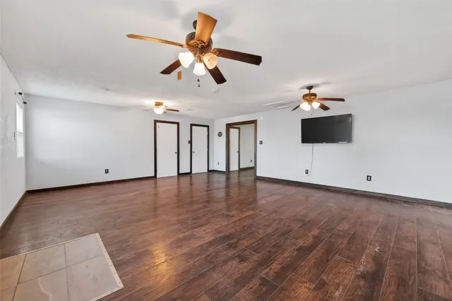 a view of a livingroom with a ceiling fan and wooden floor
