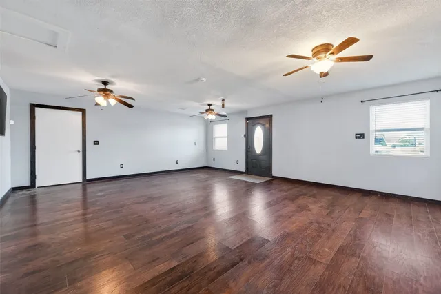 a view of a livingroom with a ceiling fan window and hardwood floor