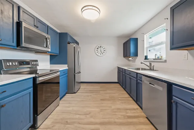 a kitchen with stainless steel appliances granite countertop a sink stove and cabinets