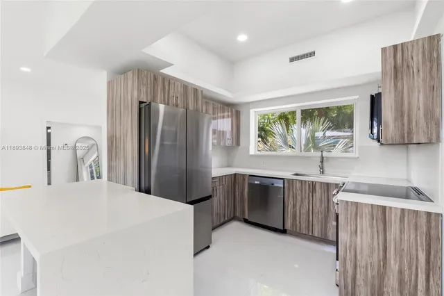 a kitchen with stainless steel appliances a refrigerator and a sink