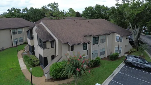 a aerial view of a house next to a big yard and large trees