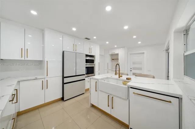 a kitchen with white cabinets sink and white appliances