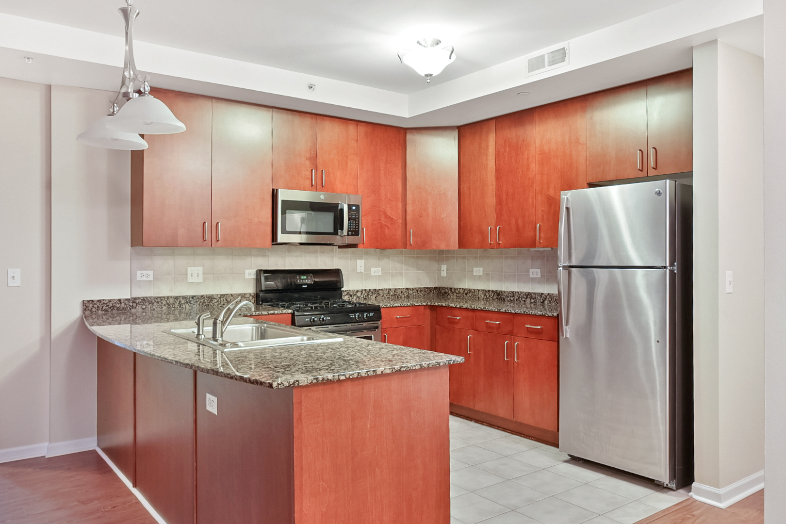135 South York Street, Unit 314 Elmhurst, IL 60126 - Photo 2 of 24 a kitchen with stainless steel appliances granite countertop a refrigerator a stove a sink and a microwave