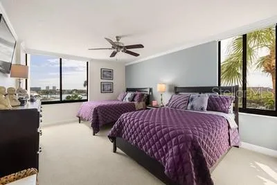 a spacious bedroom with two beds and large windows
