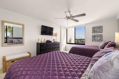 9425 Blind Pass Road, Unit 408 St. Pete Beach, FL 33706 - Photo 17 of 57 a bedroom with a large bed and a flat screen tv