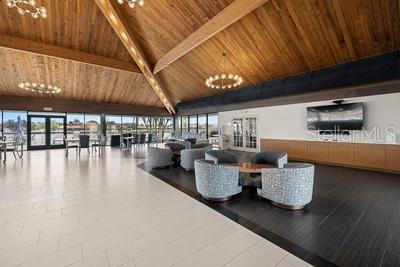 9425 Blind Pass Road, Unit 408 St. Pete Beach, FL 33706 - Photo 32 of 57 a living room with couches and kitchen view with wooden floor