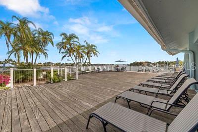 9425 Blind Pass Road, Unit 408 St. Pete Beach, FL 33706 - Photo 45 of 57 a view of a balcony with chairs and wooden floor