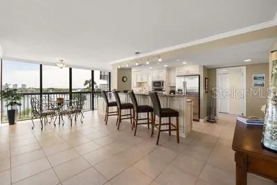a dining hall with a dining table chairs and view of living room