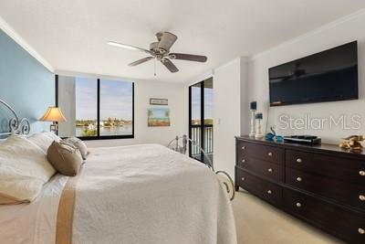 9425 Blind Pass Road, Unit 408 St. Pete Beach, FL 33706 - Photo 6 of 57 a bedroom with a bed and a flat tv screen on the dresser