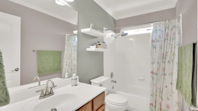 a bathroom with a sink a toilet a mirror a bathtub and shower