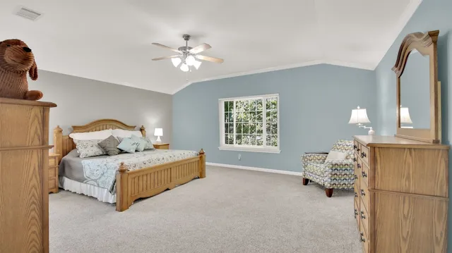 a spacious bedroom with a bed and a chandelier