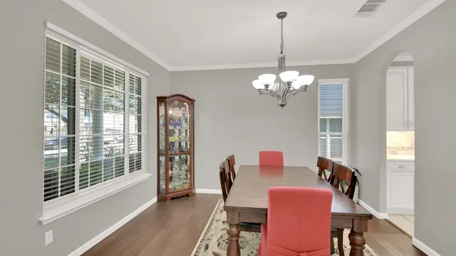 a dining room with furniture a chandelier and wooden floor