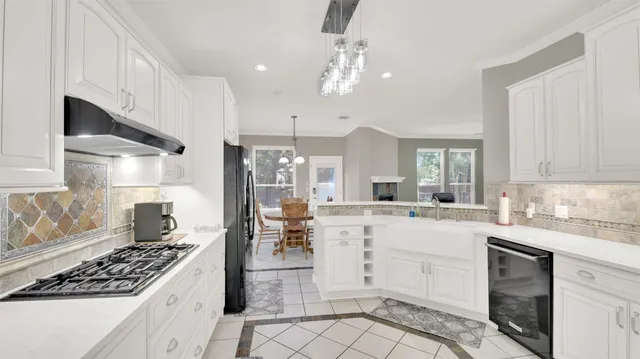 a kitchen with white cabinets and appliances