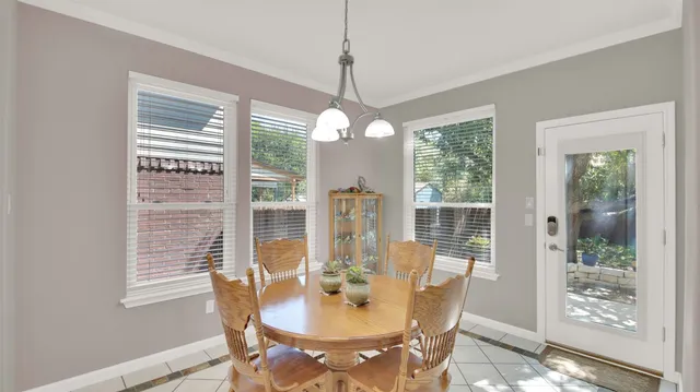 a dining room with furniture large windows and a chandelier