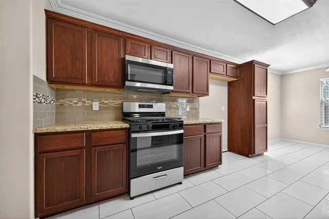 a kitchen with stainless steel appliances granite countertop a refrigerator stove and sink
