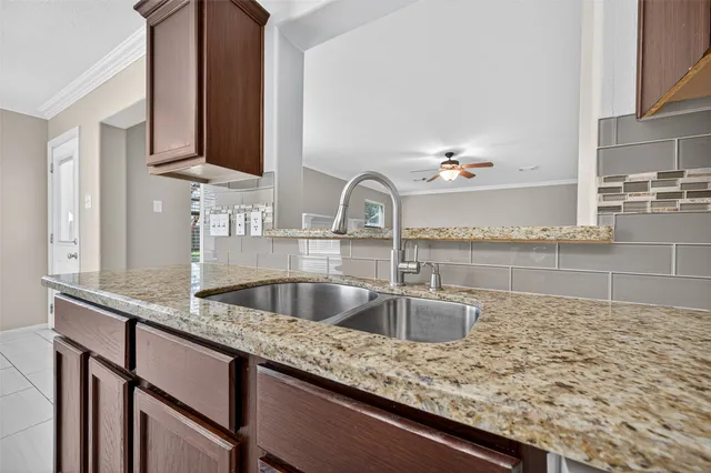 a kitchen with granite countertop a sink and cabinets