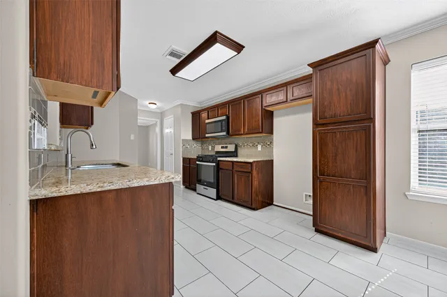 a kitchen with stainless steel appliances granite countertop a refrigerator stove and sink