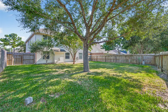 a view of a backyard with table and chairs and wooden fence