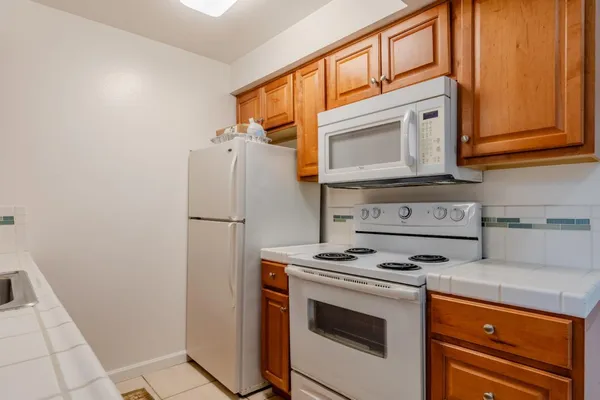 a kitchen with stainless steel appliances granite countertop a refrigerator stove and cabinets