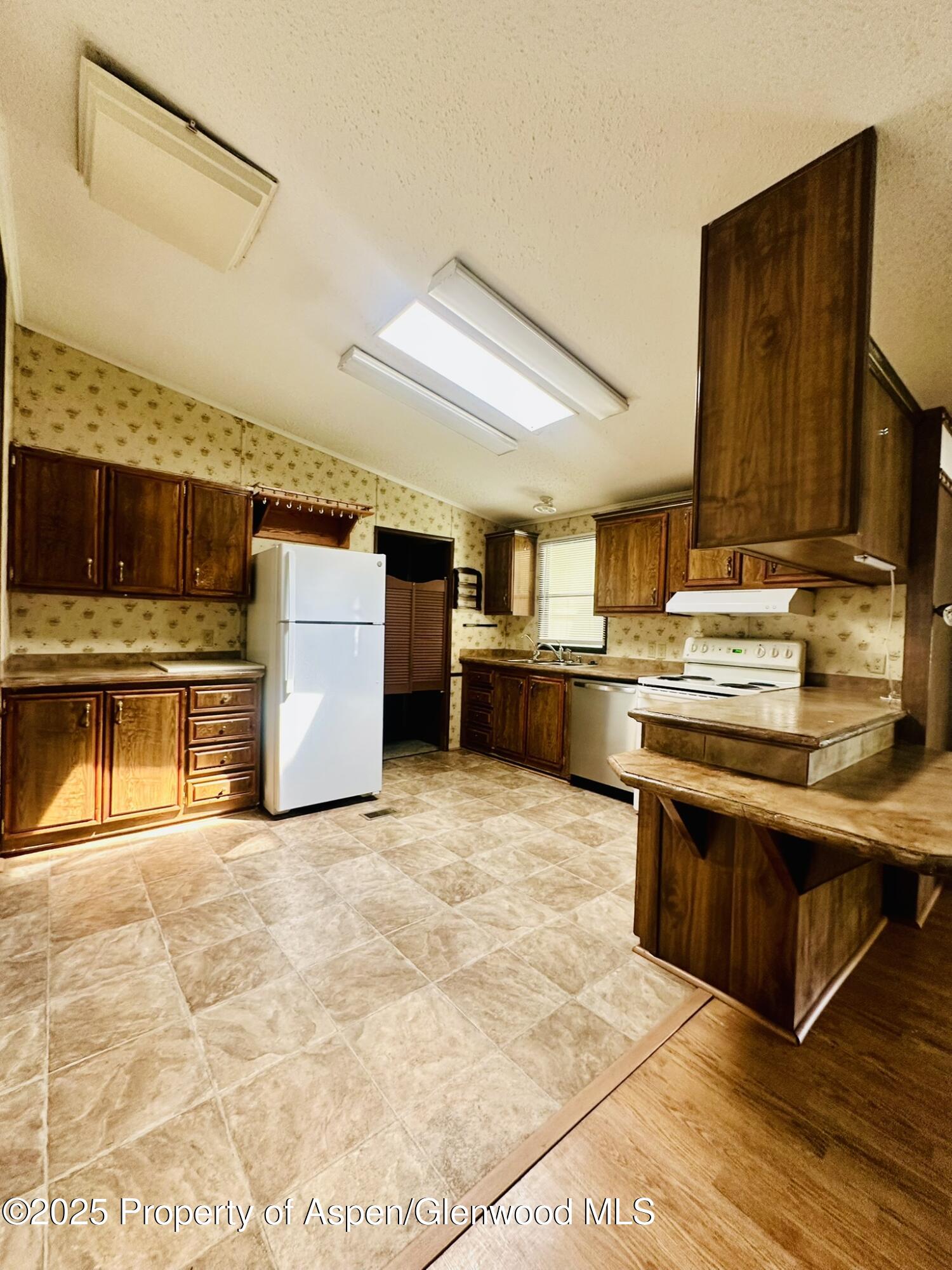 3195 F Road, Unit 1 Grand Junction, CO 81504 - Photo 5 of 22 a kitchen with stainless steel appliances granite countertop a stove a sink and a refrigerator