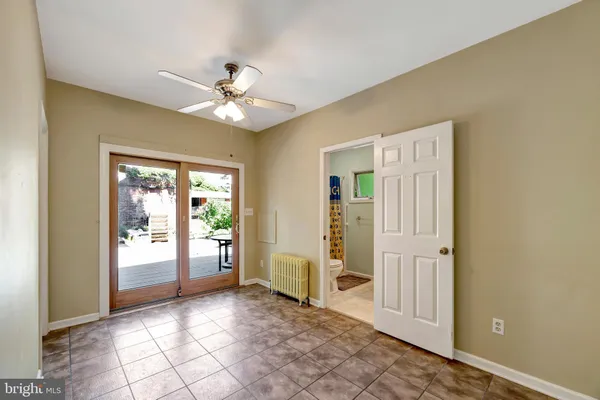 a view of a livingroom with a chandelier fan and windows