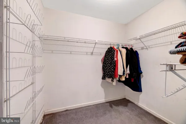 a view of walk in closet with clothes