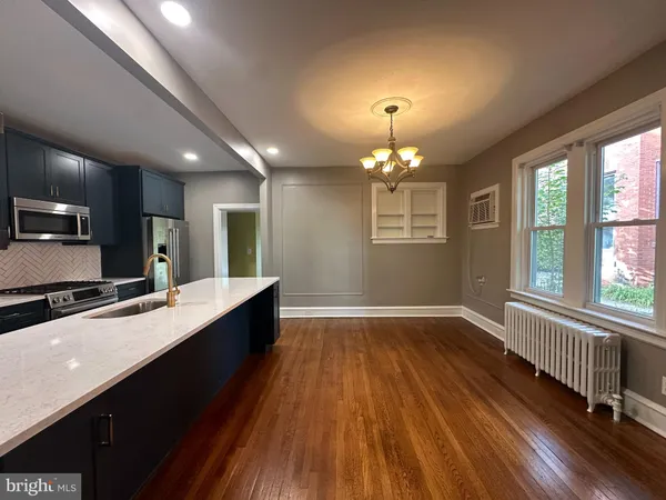 a large kitchen with kitchen island a large counter space a sink appliances and cabinets