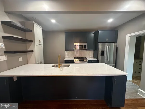 a large kitchen with kitchen island a cabinets counter space and stainless steel appliances