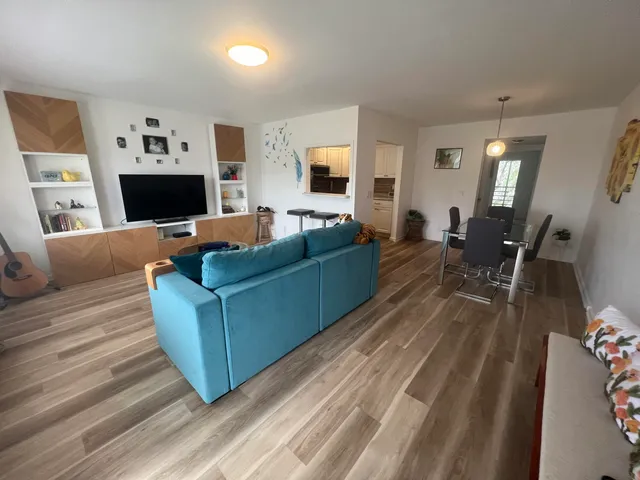 a living room with furniture and a wooden floor