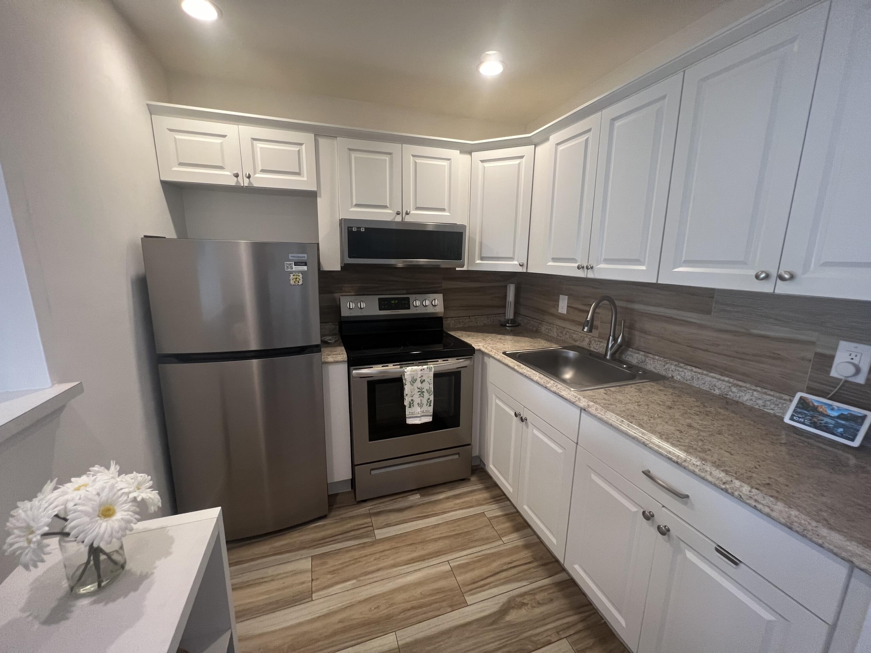79 Dorset B Boca Raton, FL 33434 - Photo 5 of 12 a kitchen with granite countertop a refrigerator stove and sink