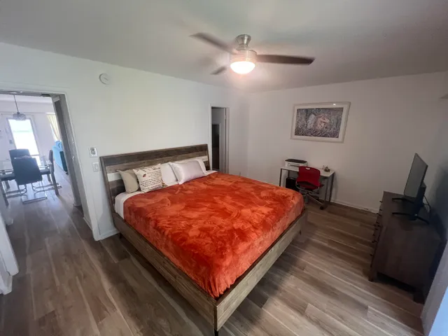 a bed sitting in a bedroom next to a lamp with wooden floor