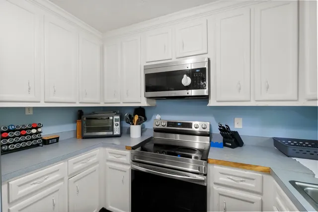 a kitchen with stainless steel appliances granite countertop a refrigerator stove microwave and cabinets