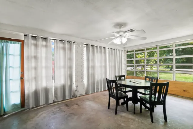 a yellow and red house with a big yard and large trees