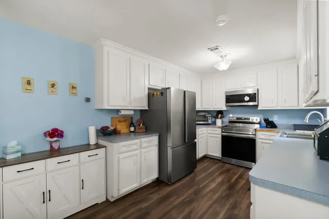 a kitchen with cabinets a sink and appliances