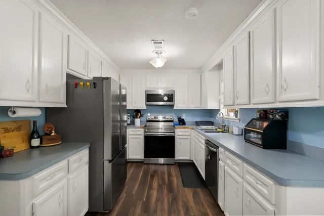 a kitchen with white cabinets and appliances