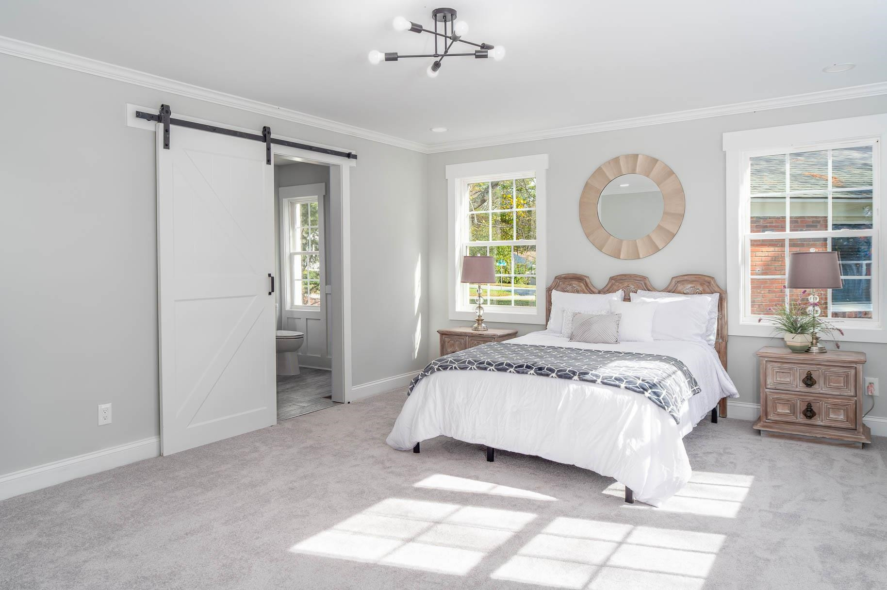 2108 Ramseur Street Raleigh, NC 27610 - Photo 17 of 26 a bedroom with a bed and a chandelier