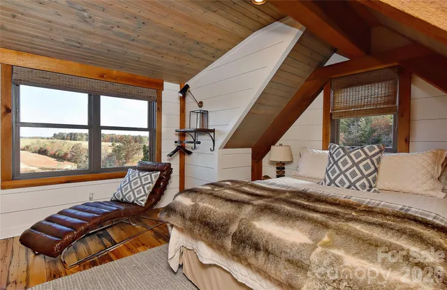 a bedroom with furniture and a large window