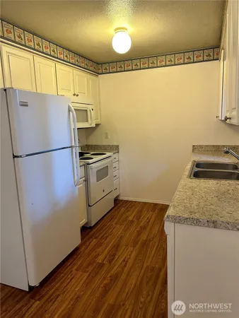 a view of a room with wooden floor and white walls