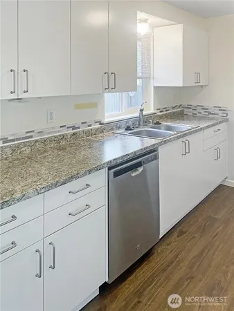 a kitchen with stainless steel appliances granite countertop a sink a stove and cabinets