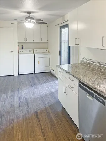 a kitchen with a sink cabinets and wooden floor